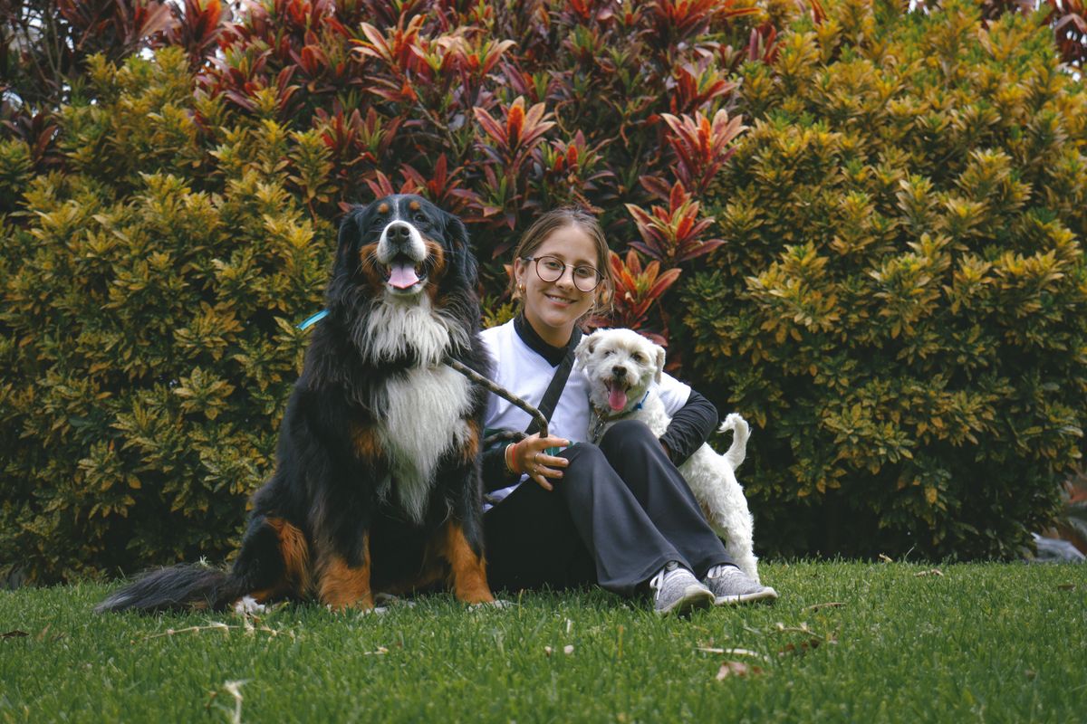 Cuidadora com dois cães no jardim